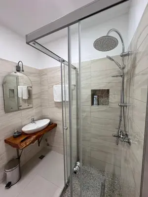 a bathroom with a glass shower and a sink at Ravne Energy Apartments in Visoko