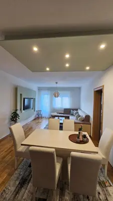 a dining room and living room with a table and chairs at Apartman Pati in Livno