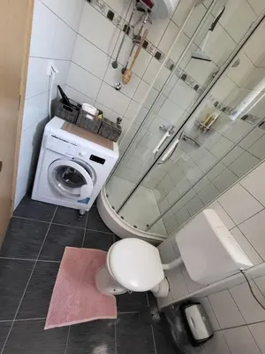 a bathroom with a toilet and a washing machine at Apartman Pati in Livno