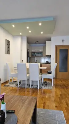 a living room with a table and white chairs at Apartman Pati in Livno