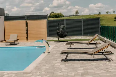a swimming pool with two lounge chairs next to it at Villa Lamija in Bihać