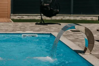a pool with a water fountain in a yard at Villa Lamija in Bihać