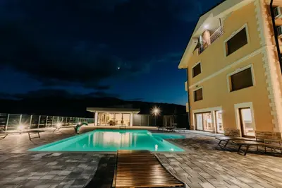 a swimming pool in front of a building at night at Villa Lamija in Bihać