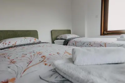 a bedroom with two beds and a mirror at Villa Lamija in Bihać