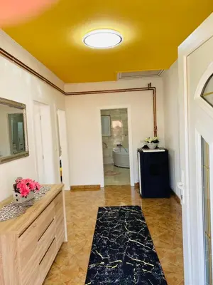 a bathroom with a yellow ceiling and a room at Apartman Kula in Gradačac