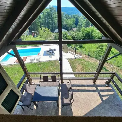 a view of a patio with a table and chairs and a pool at Vikendica Nature park Banja Luka in Banja Luka