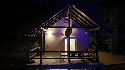 a small house is lit up at night at Vikendica Nature park Banja Luka in Banja Luka