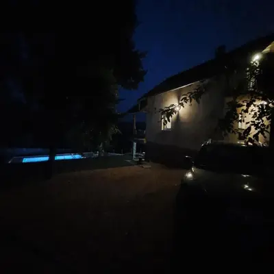 a dark room with a building at night at Vikendica Nature park Banja Luka in Banja Luka