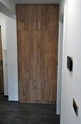 a large wooden cabinet in a room with a wall at Park Lake - Germa in Tuzla