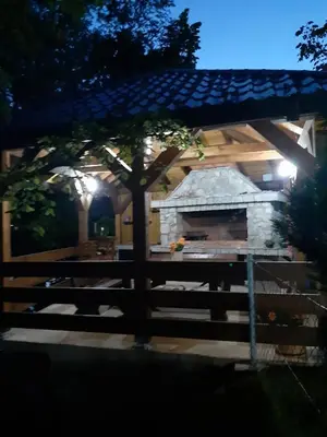 a stone building with a tree and a wooden fence at Lahor in Bihać