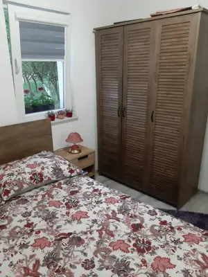 a bedroom with a bed and a dresser and a window at Lahor in Bihać