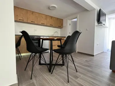 a kitchen with a table and four black chairs at Villa Pampas in Banja Luka