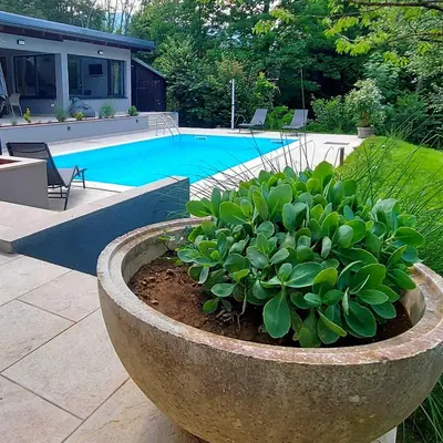 a large stone planter next to a swimming pool at Villa Pampas in Banja Luka