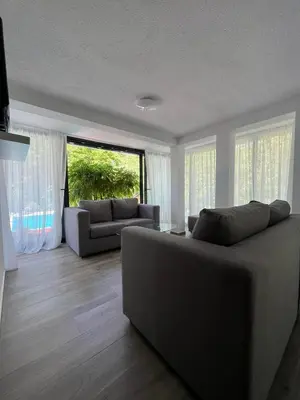 a living room with a couch and a large window at Villa Pampas in Banja Luka