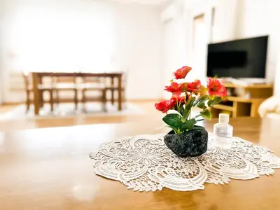 a vase with red flowers on a table at Daman Villa in Bihać