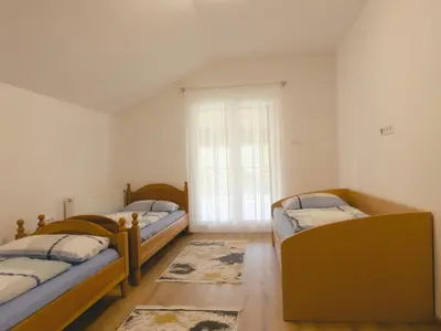 a room with three beds and a window at Daman Villa in Bihać