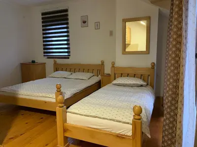 two twin beds in a room with a mirror at Vila Sana in Landeke