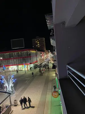 a group of people walking down a street at night at Apartman CITY CENTER 4-šetalište in Prijedor