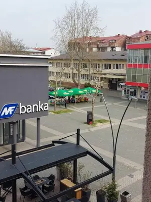 a picnic table in front of a building with aania sign at Apartman CITY CENTER 4-šetalište in Prijedor