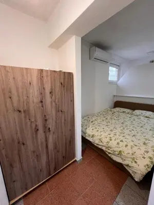 a bedroom with a bed and a large wooden door at Babici 3 in Hiseti