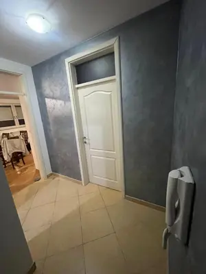 a hallway with a white door and a tile floor at Apartman Lana in Doboj