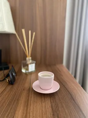 a cup on a plate on a wooden table at Mia apartman Visoko in Visoko