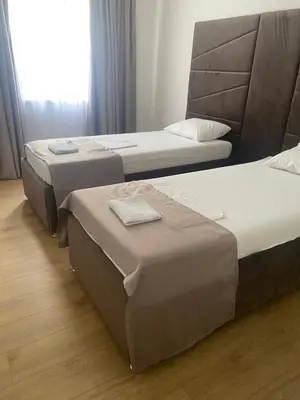 three beds in a hotel room with a window at Mia apartman Visoko in Visoko