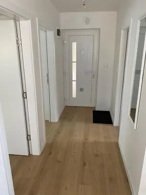 an empty hallway with white walls and wood floors at Mia apartman Visoko in Visoko