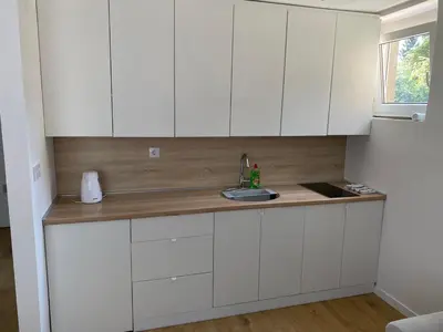 a kitchen with white cabinets and a sink at Mia apartman Visoko in Visoko