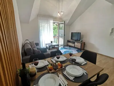 a living room with a wooden table with plates on it at King's Cave deluxe in Jajce