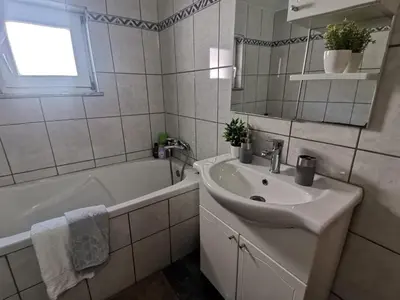 a white bathroom with a sink and a tub and a sink at King's Cave deluxe in Jajce