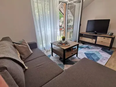 a living room with a couch and a tv at King's Cave deluxe in Jajce