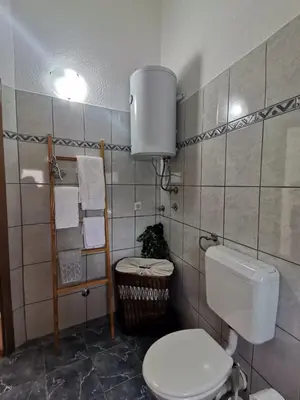 a bathroom with a toilet and a towel rack at King's Cave deluxe in Jajce
