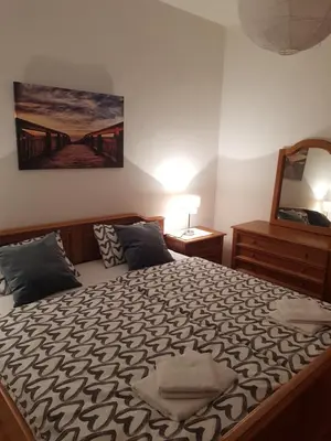 a bedroom with a large bed with a painting on the wall at Apartman Buongiorno in Jajce