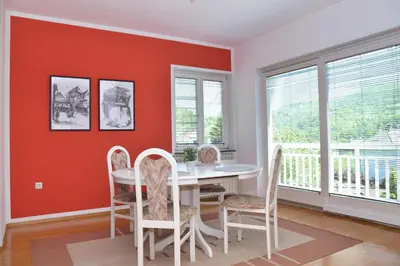 a dining room with red walls and a white table and chairs at Apartman Buongiorno in Jajce