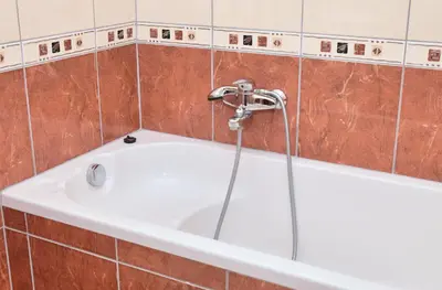 a bath tub with a shower in a tiled bathroom at Apartman Buongiorno in Jajce
