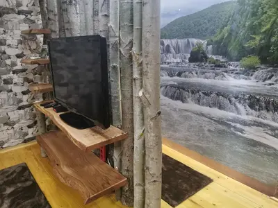 a tv sitting on a stand next to a waterfall at Rest House Ripac in Praščijak