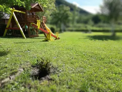 a playground with a slide in the grass at Rest House Ripac in Praščijak