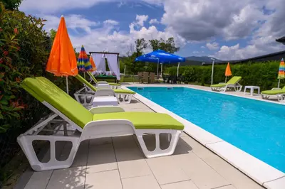 a pool with lounge chairs and umbrellas next to it at Holiday Home Bonum in Bihać
