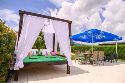 a patio with a table and a blue umbrella at Holiday Home Bonum in Bihać