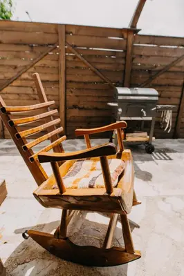 a wooden rocking chair sitting on top of a patio at Holiday Home Bonum in Bihać