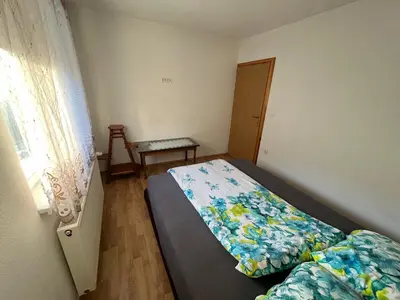 a small bedroom with a bed and a window at Apartmani Piramida Mjeseca i Sunca in Visoko
