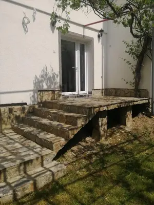 a stone bench in front of a house at Studio by the river in Jajce