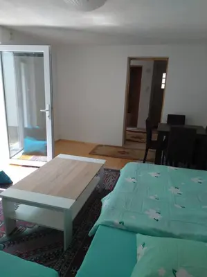 a living room with a wooden table and a couch at Studio by the river in Jajce