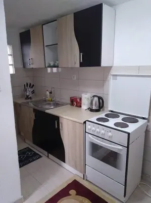 a small kitchen with a stove and a sink at Studio by the river in Jajce