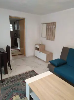 a living room with a blue couch and a table at Studio by the river in Jajce