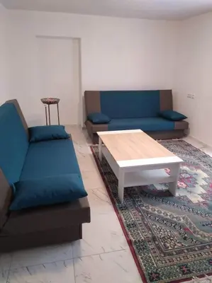 a living room with two blue couches and a coffee table at Studio by the river in Jajce