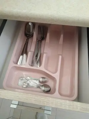 a pink tray with silver utensils in a cabinet at Studio by the river in Jajce