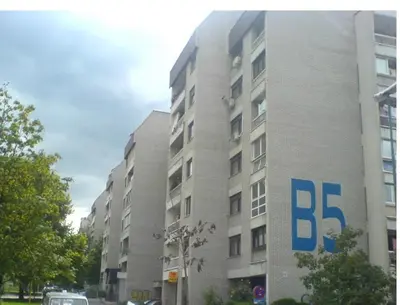 a building with a sign on the side of it at A First class za 4 osobe 2 spavaće sobe in Tuzla
