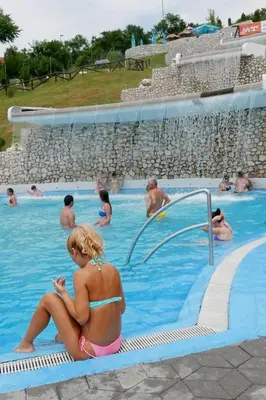 a woman in a bikini sitting in a swimming pool at A First class za 4 osobe 2 spavaće sobe in Tuzla
